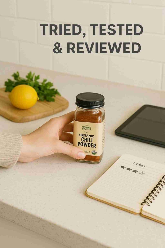 Flat lay of a branded food product on a kitchen counter with a hand holding it, open notebook with review notes, natural daylight, and subtle food elements in the background – representing honest product reviews for a food blog.